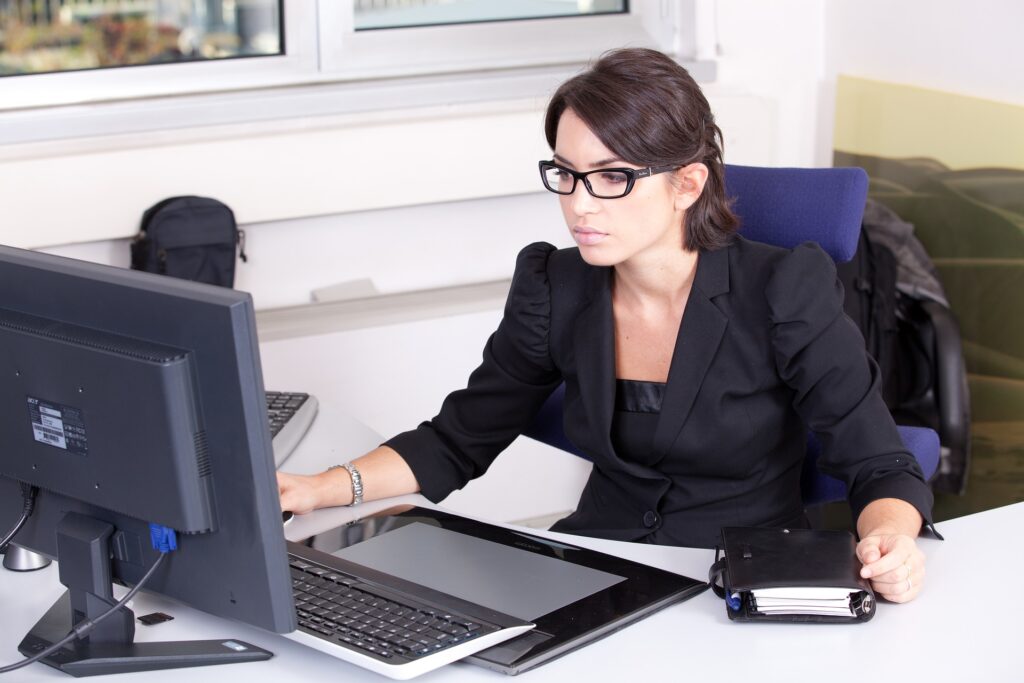 パソコンを見る黒いスーツを着た女性